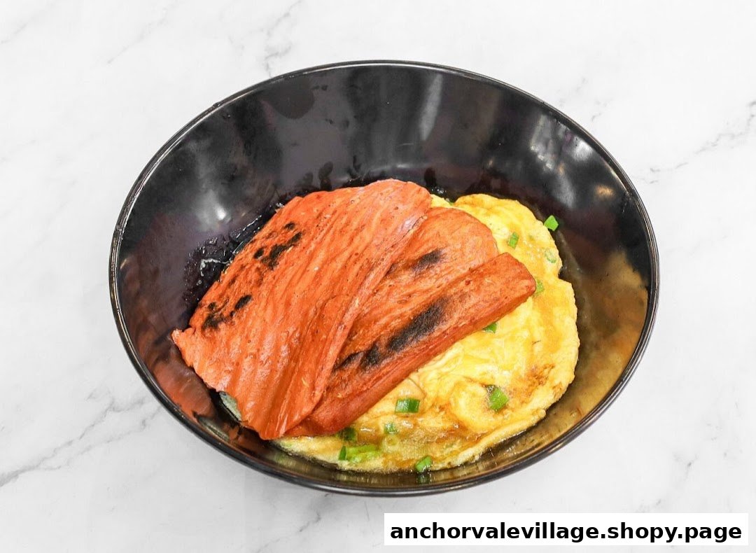 A close-up of a bowl containing grilled spam slices and fluffy scrambled eggs with spring onions.