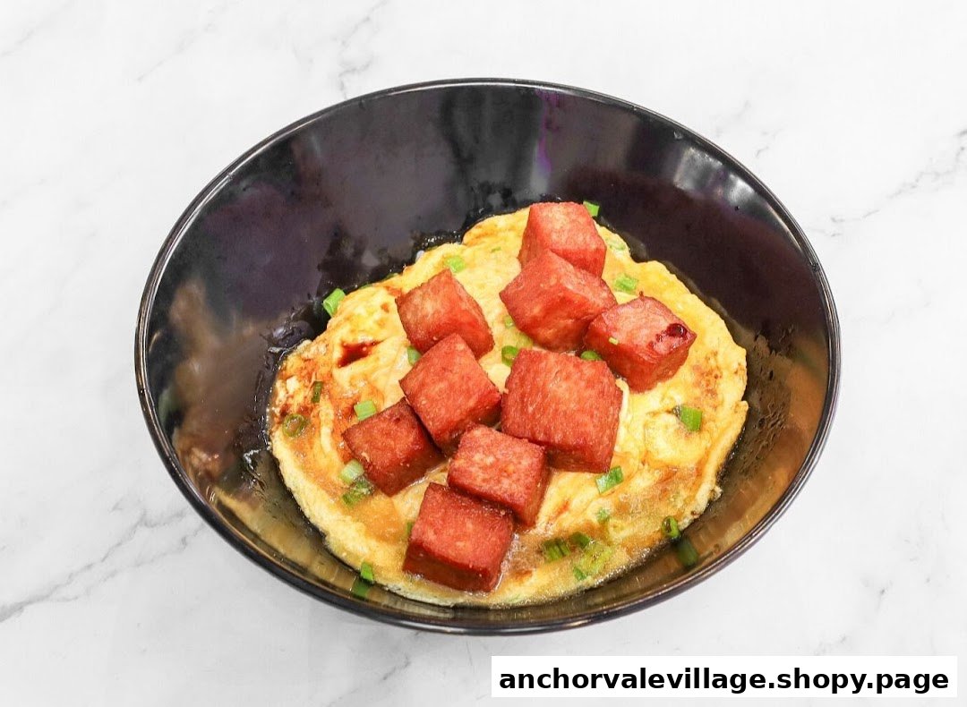 A savory dish with a fried egg base topped with cubed spam and green onions in a black bowl.