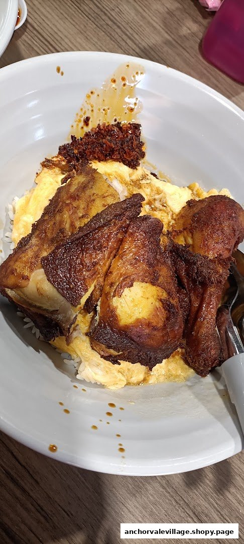 A close-up of a delicious meal featuring crispy fried chicken, fluffy egg, rice, and chili in a bowl.