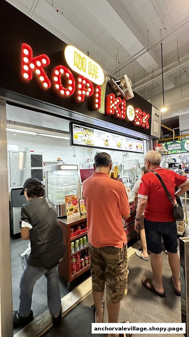 Customers queue at the Kopi Kiosk storefront, featuring its bright signage and menu display.