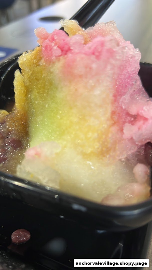 A vibrant, colorful shaved ice dessert with various toppings in a black bowl, ready to be enjoyed.