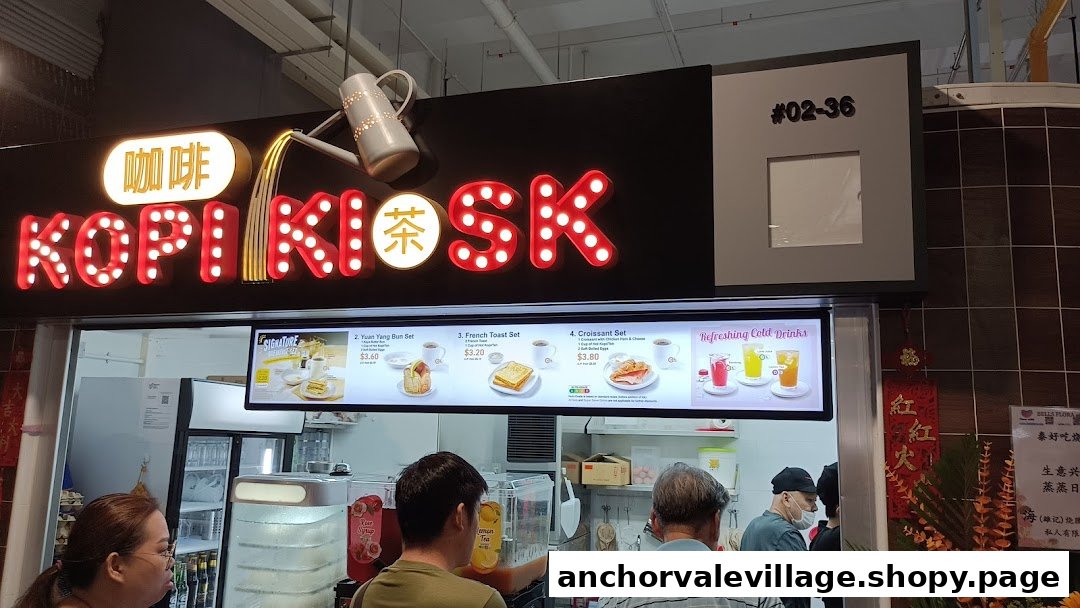 The illuminated Kopi Kiosk shop front features its distinctive sign and a digital menu board.