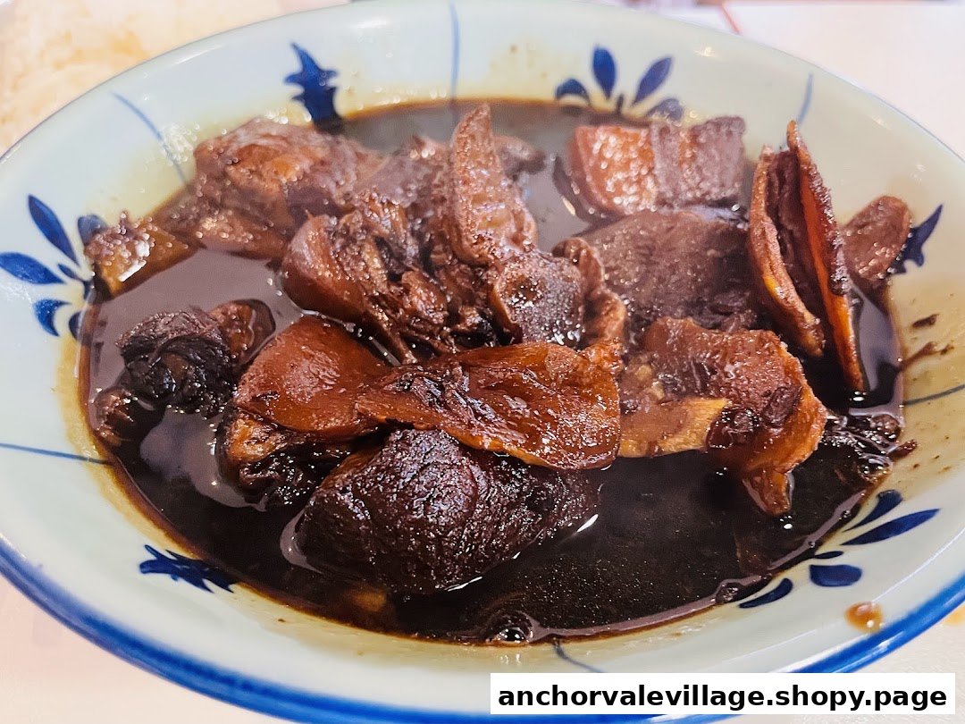 A close-up of a bowl of dark braised meat and ingredients in a traditional patterned bowl.