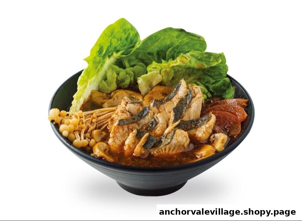 A vibrant bowl of fish soup with fresh lettuce, various mushrooms, and other ingredients.