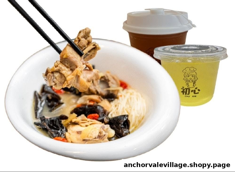 A close-up of a hearty chicken soup with noodles and mushrooms, served with two refreshing drinks.