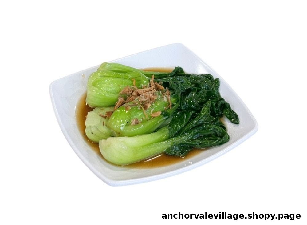 A plate of vibrant green vegetables with savory sauce and crispy fried shallots.