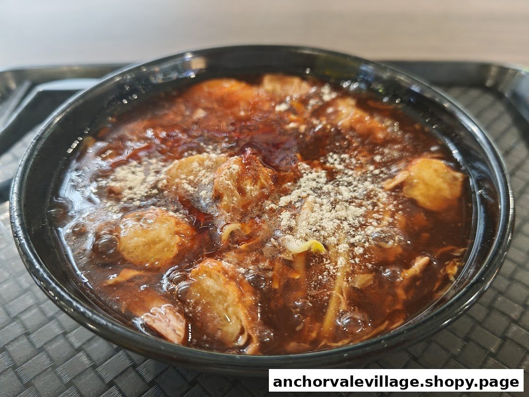 A close-up of a delicious bowl of Yong Tau Foo with rich dark sauce and various ingredients.