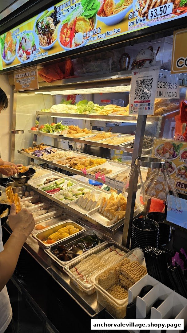 A customer selects fresh ingredients from a wide array of Yong Tau Foo items at a bustling food stall.