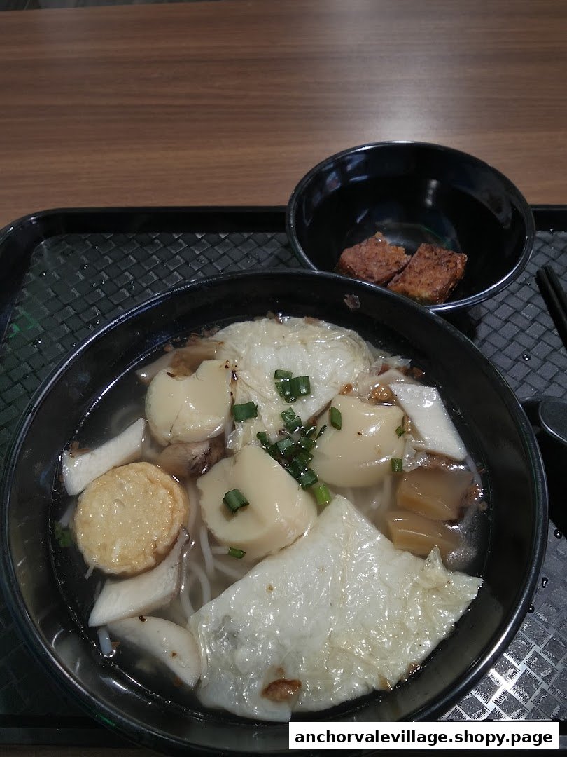 A close-up of a delicious bowl of Yong Tau Foo noodles with various fresh ingredients and a side dish.