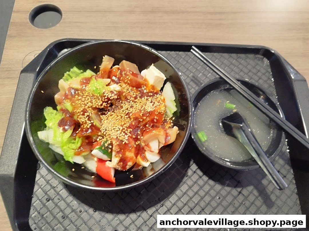 A delicious bowl of Yong Tau Foo with chili sauce and sesame seeds, served with a side of clear soup.