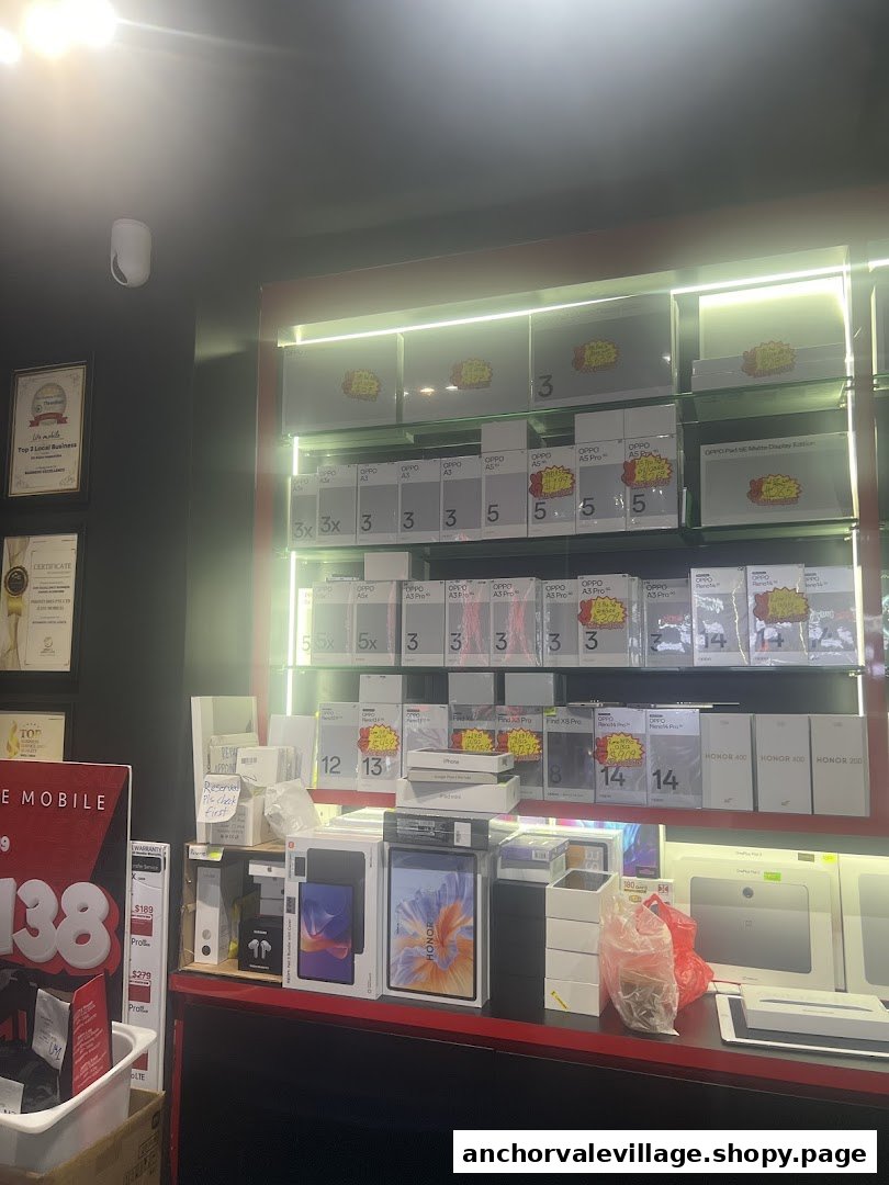 Interior view of a mobile phone shop displaying various smartphone and tablet models on illuminated shelves.