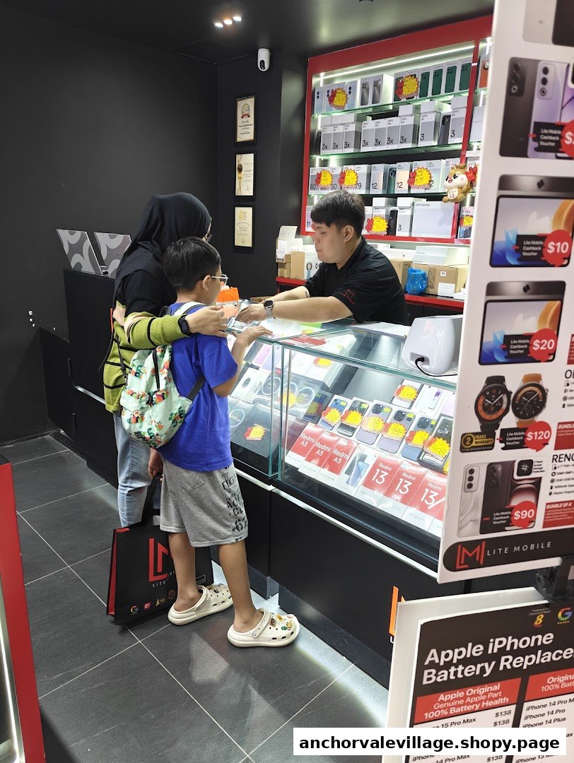 Customers interacting with staff at a mobile phone shop counter displaying various smartphones and accessories.