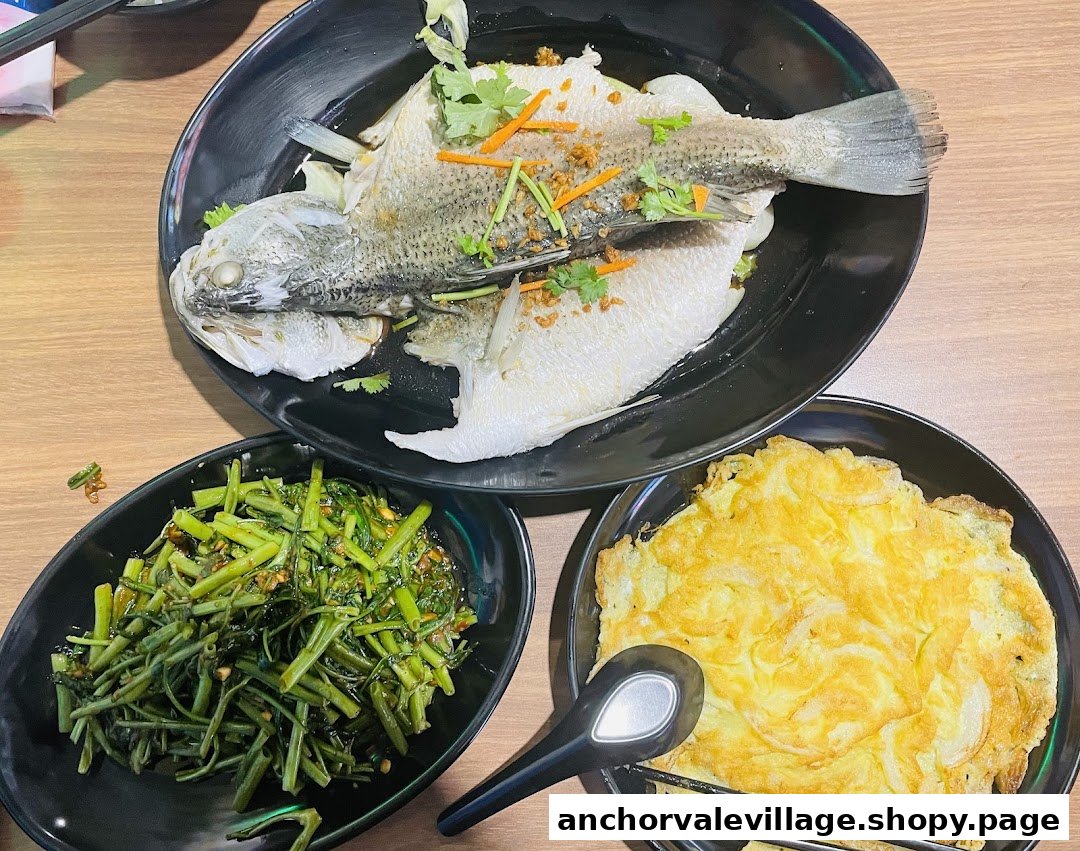 A delicious spread featuring steamed fish, stir-fried greens, and a fluffy omelet from Long Ding Seafood.