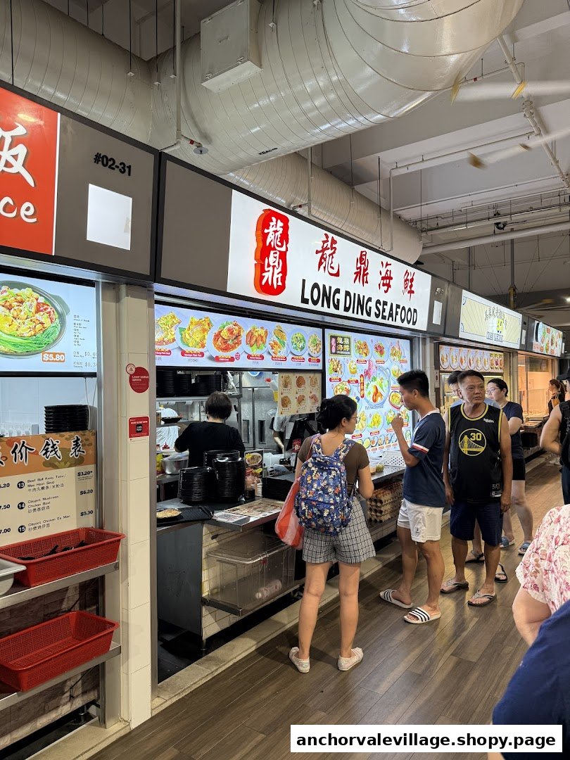 Customers queue at Long Ding Seafood, a bustling stall showcasing various seafood dishes and a vibrant atmosphere.