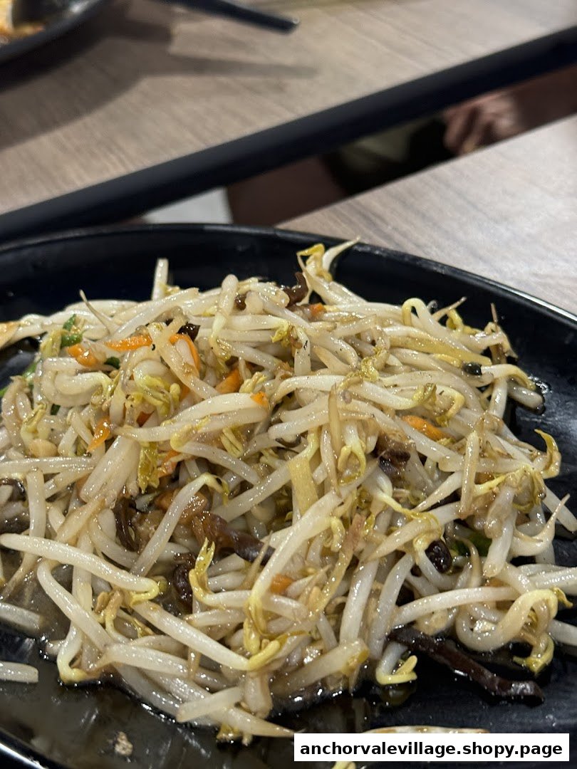 A close-up of a delicious plate of stir-fried bean sprouts with vegetables and mushrooms.