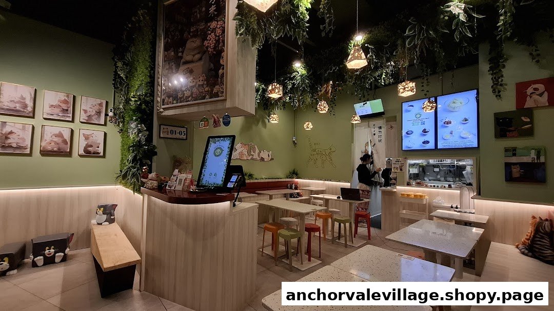 A cozy, cat-themed interior of Meow Dessert with seating, a counter, and digital menu displays.