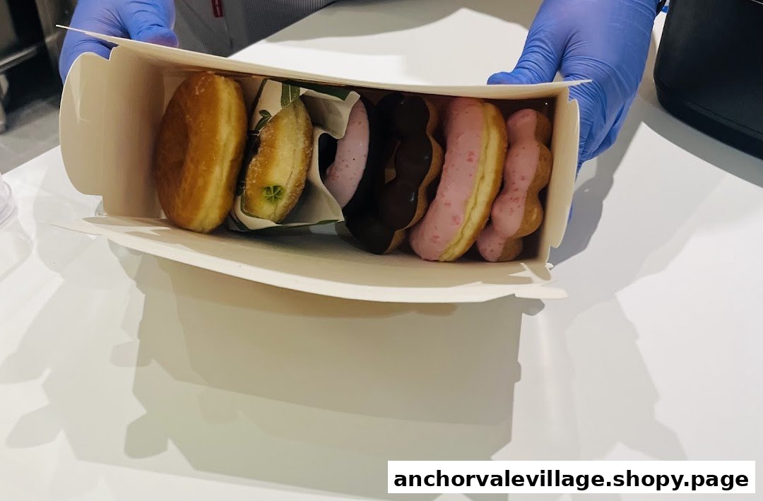 A hand in blue gloves holds a box filled with assorted delicious donuts from Mister Donut.