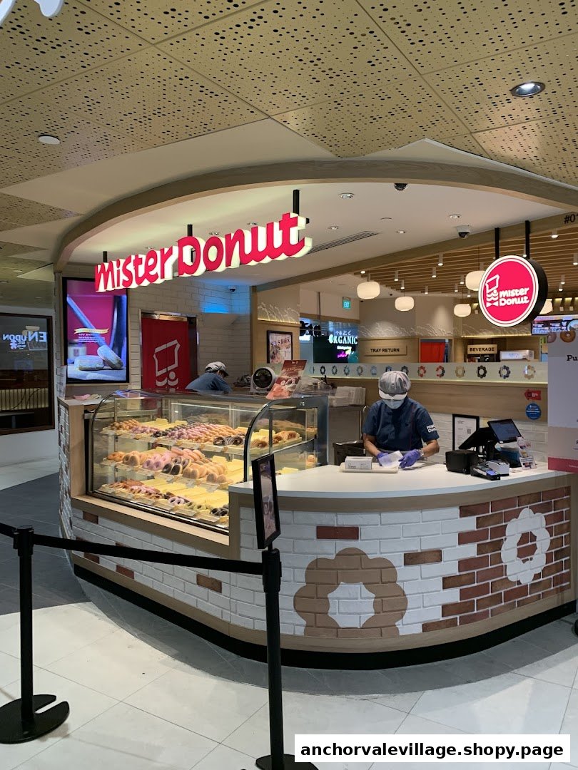 An interior view of Mister Donut at Anchorvale Village, showcasing donut displays and staff.