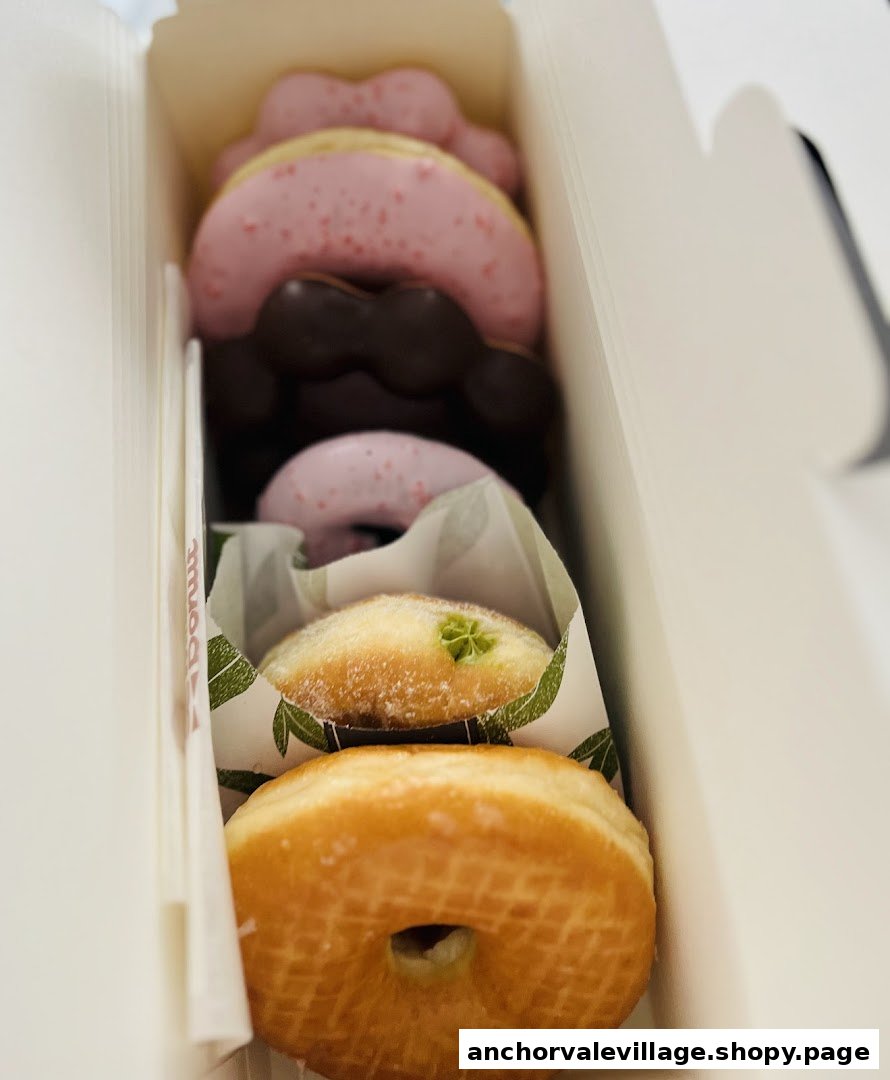 A box of assorted Mister Donut pastries, including classic and character-shaped donuts.