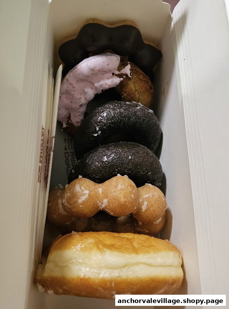 A box filled with assorted Mister Donut pastries, including chocolate, mochi, and classic glazed donuts.