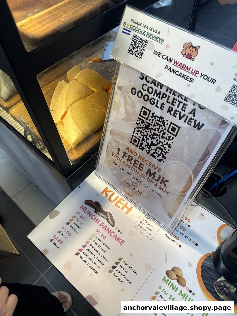 A close-up of Munchi Pancakes' counter, showcasing their menu, delicious pancakes, and customer review promotions.