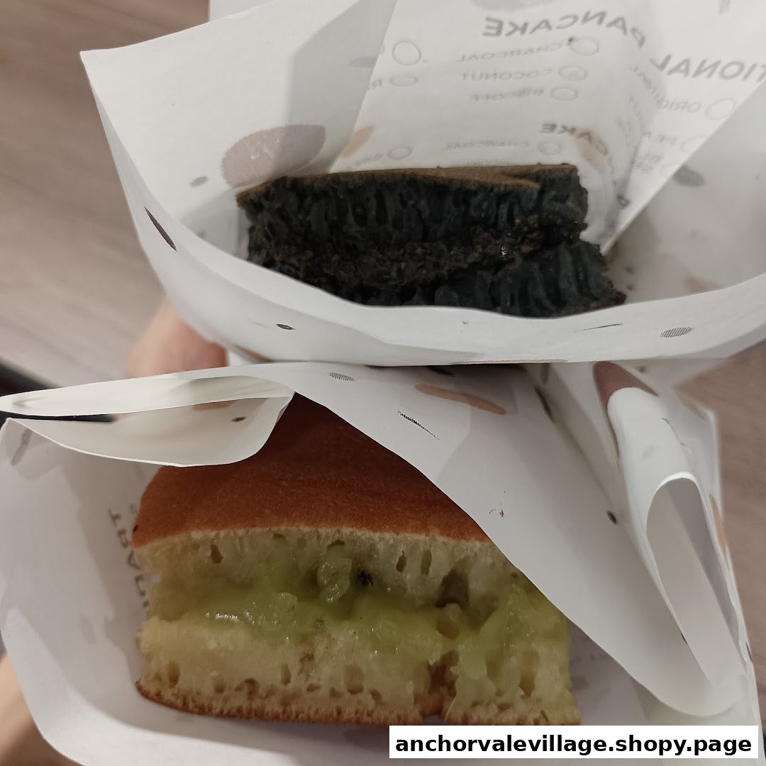Two delicious Munchi Pancakes, one with green filling and one dark, held in paper wrappers.