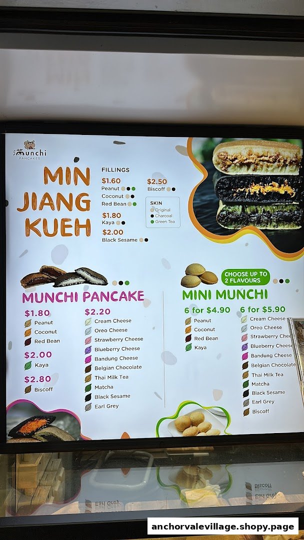A vibrant menu board for Munchi Pancakes, showcasing various pancake types, fillings, and prices.