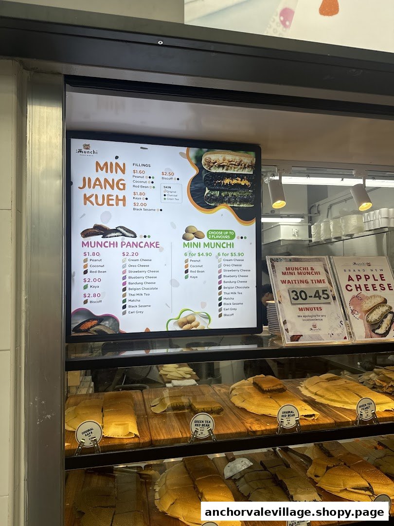A vibrant digital menu board for Munchi Pancakes, showcasing various pancake types, fillings, and prices.