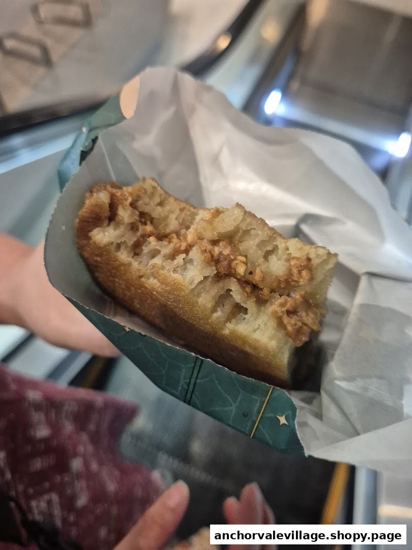 A close-up of a delicious Munchi Pancake, revealing its fluffy texture and peanut filling, held in its signature wrapper.