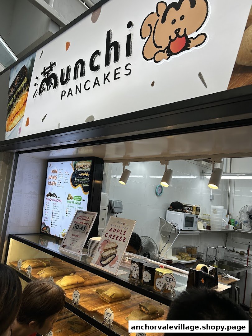 A bustling counter at Munchi Pancakes showcasing freshly made pancakes and a digital menu board.
