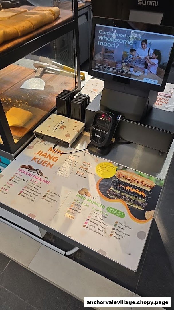A counter at Munchi Pancakes displaying various pancake and kueh options with prices.