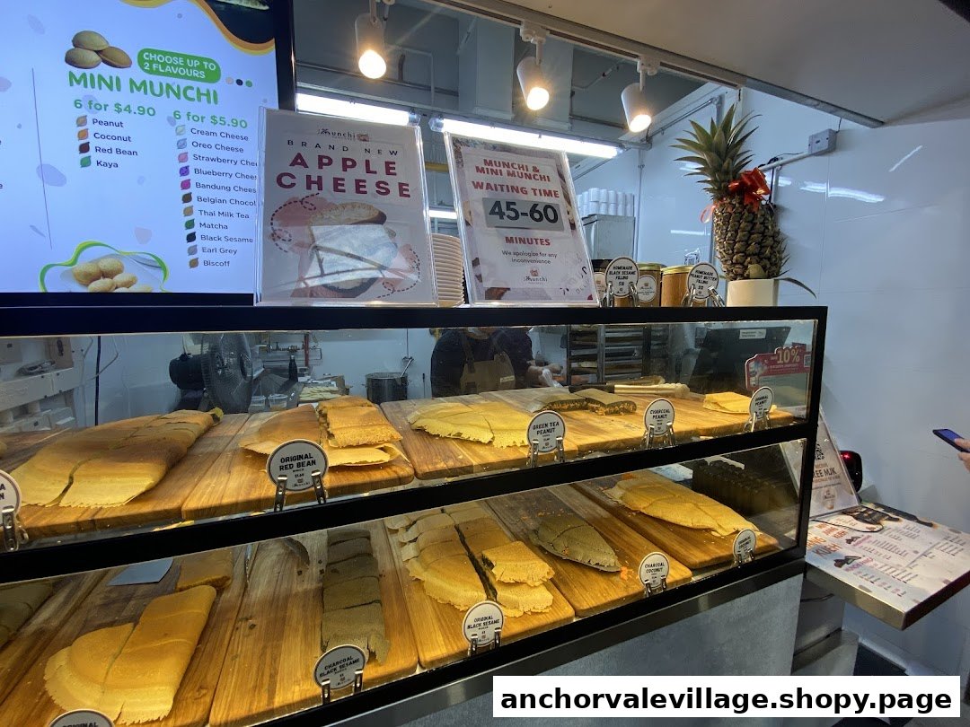 A vibrant display case showcasing various Munchi pancakes and a menu board with diverse flavor options.