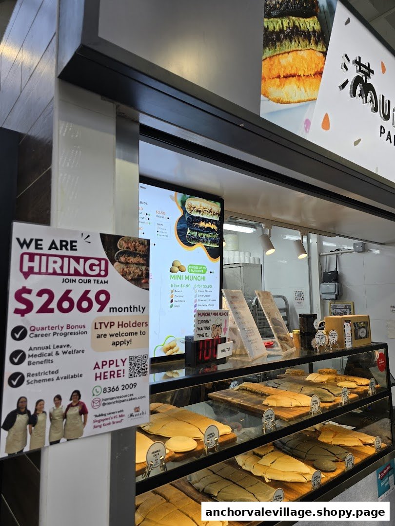 A display counter at Munchi Pancakes showcasing various freshly made pancakes, with a digital menu screen.