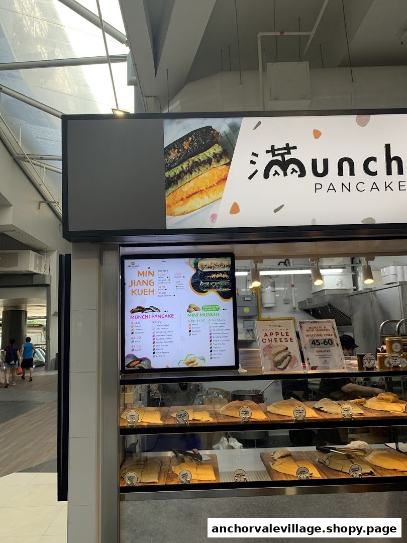 A vibrant shop front of Munchi Pancakes, showcasing their delicious pancakes and a digital menu.