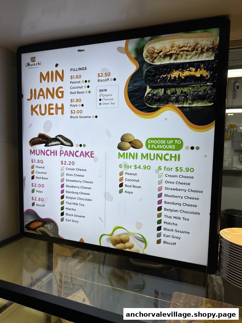 A brightly lit menu board for Munchi Pancakes, displaying various pancake types, fillings, and prices.
