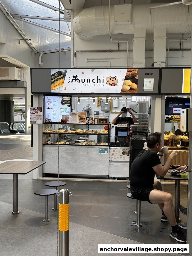 Interior view of Munchi Pancakes food stall with staff, customers, and display cases.