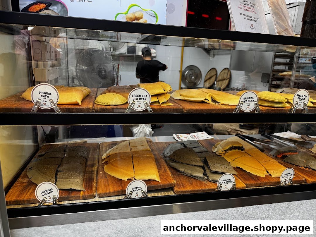 A display case showcasing various freshly made pancakes with different fillings at Munchi Pancakes.