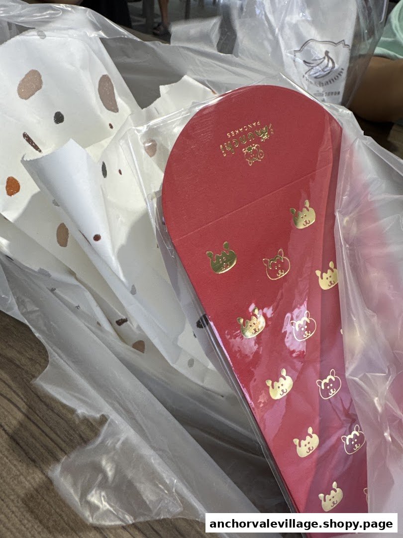 Close-up of Munchi Pancakes' signature red packaging with golden bear motifs, ready for takeaway.