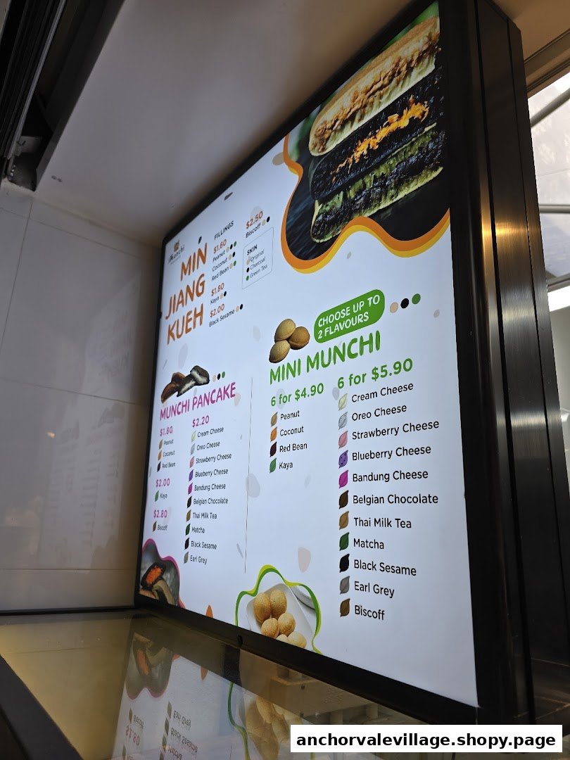 A brightly lit digital menu board displaying various pancake and filling options at Munchi Pancakes.