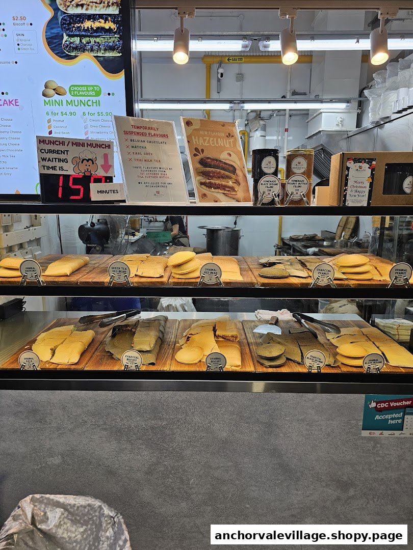 A vibrant counter displaying Munchi Pancakes, a digital menu board, and promotional signs.