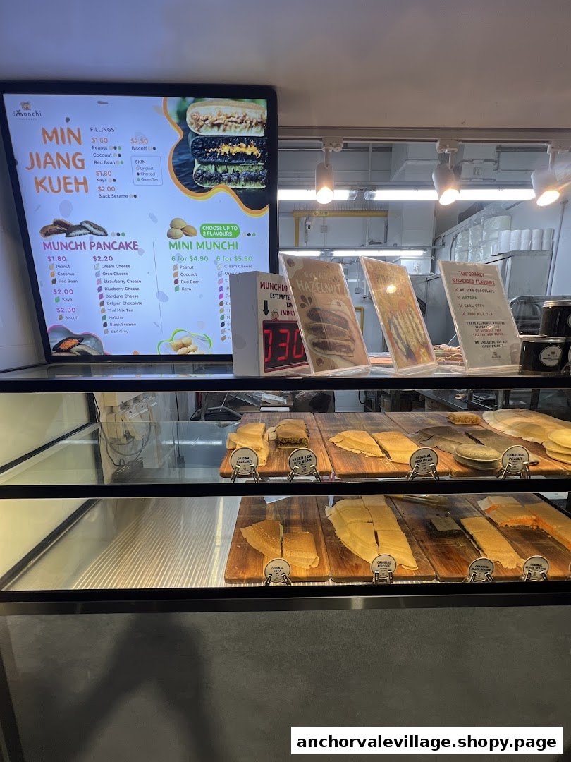 A digital menu board displaying pancake and kueh options, with a display case of freshly made items.