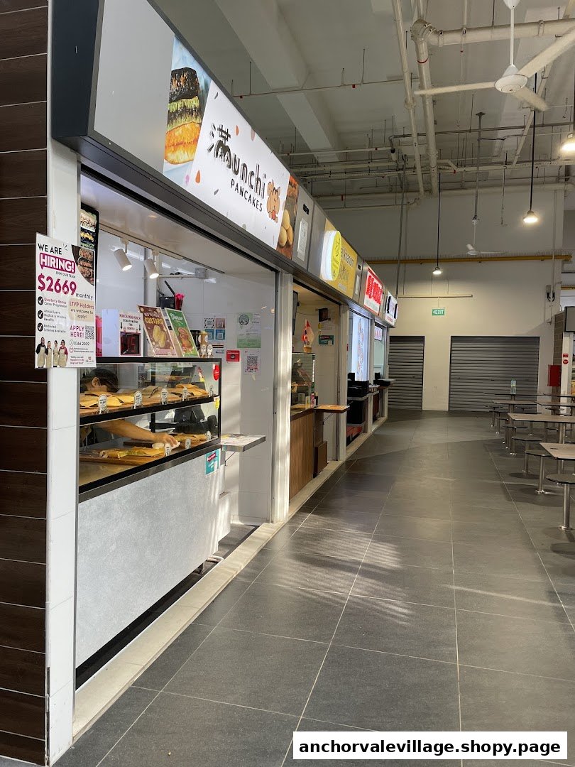 The storefront of Munchi Pancakes, a food stall, showcasing its signage and display counter.