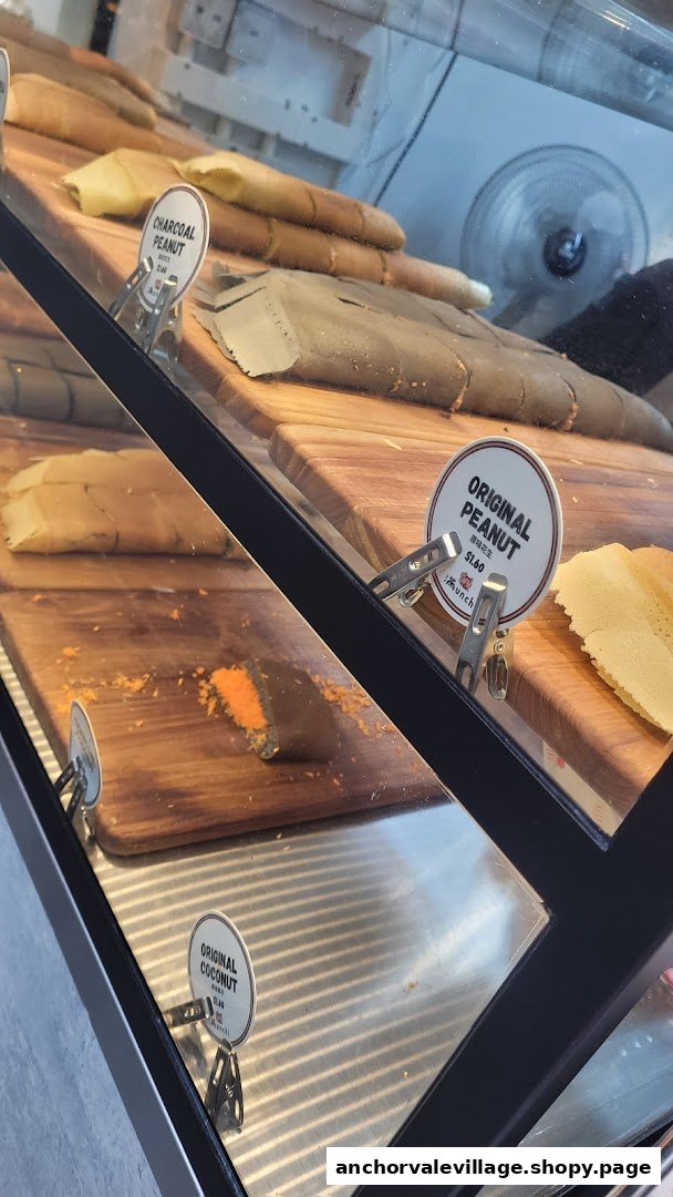 A display case showcasing various Munchi Pancakes, including Charcoal Peanut, Original Peanut, and Original Coconut flavors.