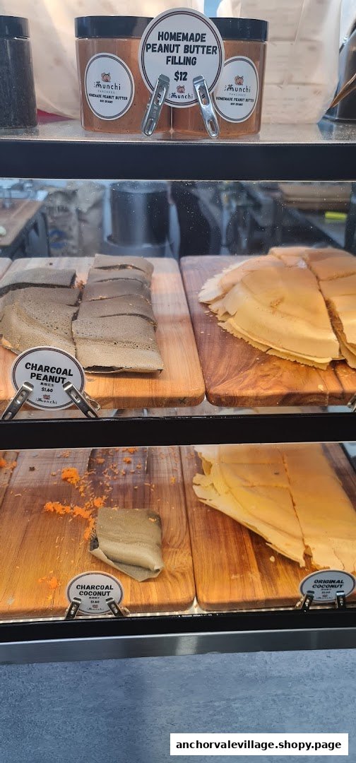 A display counter showcasing various Munchi Pancakes, including Charcoal Peanut, Charcoal Coconut, and Homemade Peanut Butter Filling.