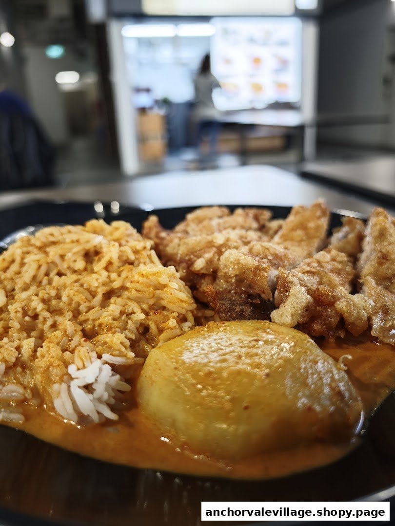 A close-up of Nanyang Curry's signature dish featuring curry rice, fried chicken, and a potato.