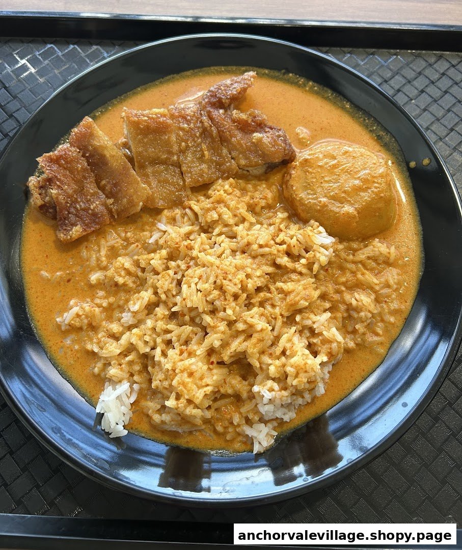 A plate of Nanyang Curry rice with crispy pork and a fish cake.