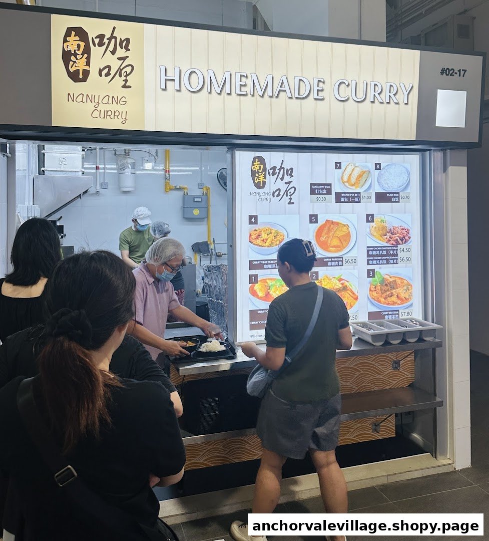 Customers queueing at the Nanyang Curry food stall with its menu display and staff serving.