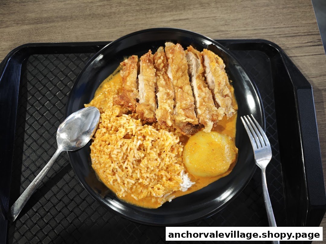 A delicious plate of Nanyang Curry chicken cutlet with rice and potato.