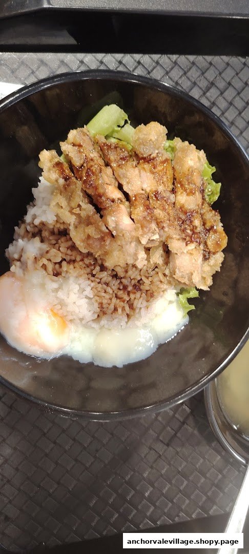 A close-up of a delicious fried chicken cutlet rice bowl with a soft-boiled egg.