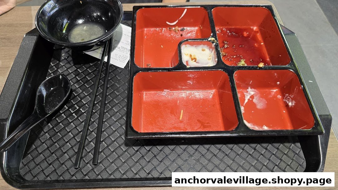 A used bento box and bowl on a tray after a meal at Oishii Shokudo.